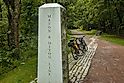 Two bikes are parked by a concrete marker indicating the location where the Great Allegheny Passage crosses the Mason Dixon Line near Frostburg, PA.