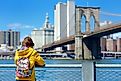 Young woman sightseeing at the Brooklyn Bridge, New York.