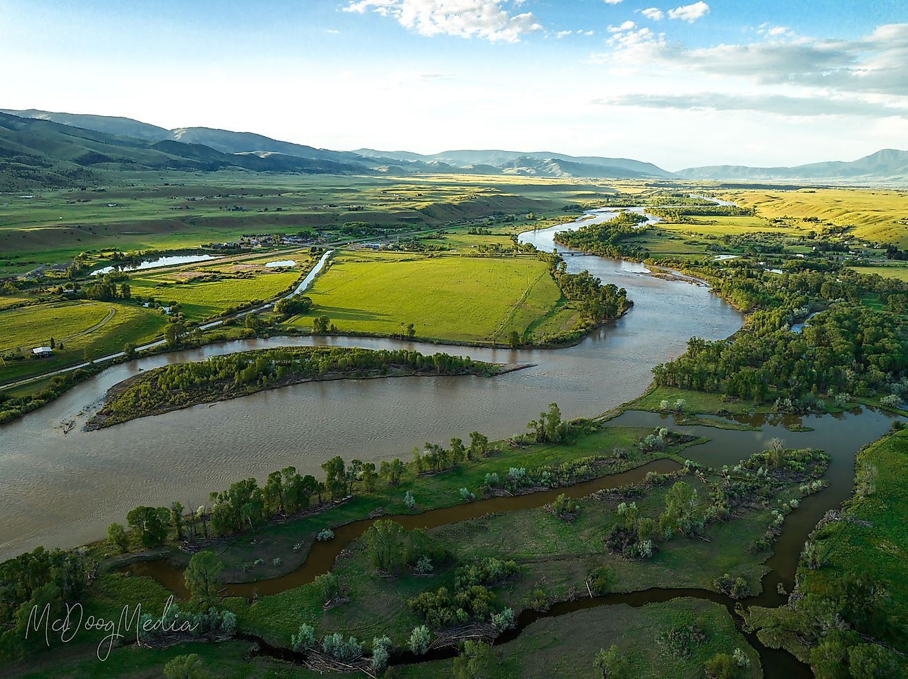A breathtaking aerial view of Paradise Valley and Yellowstone River under a bright cloudy sky