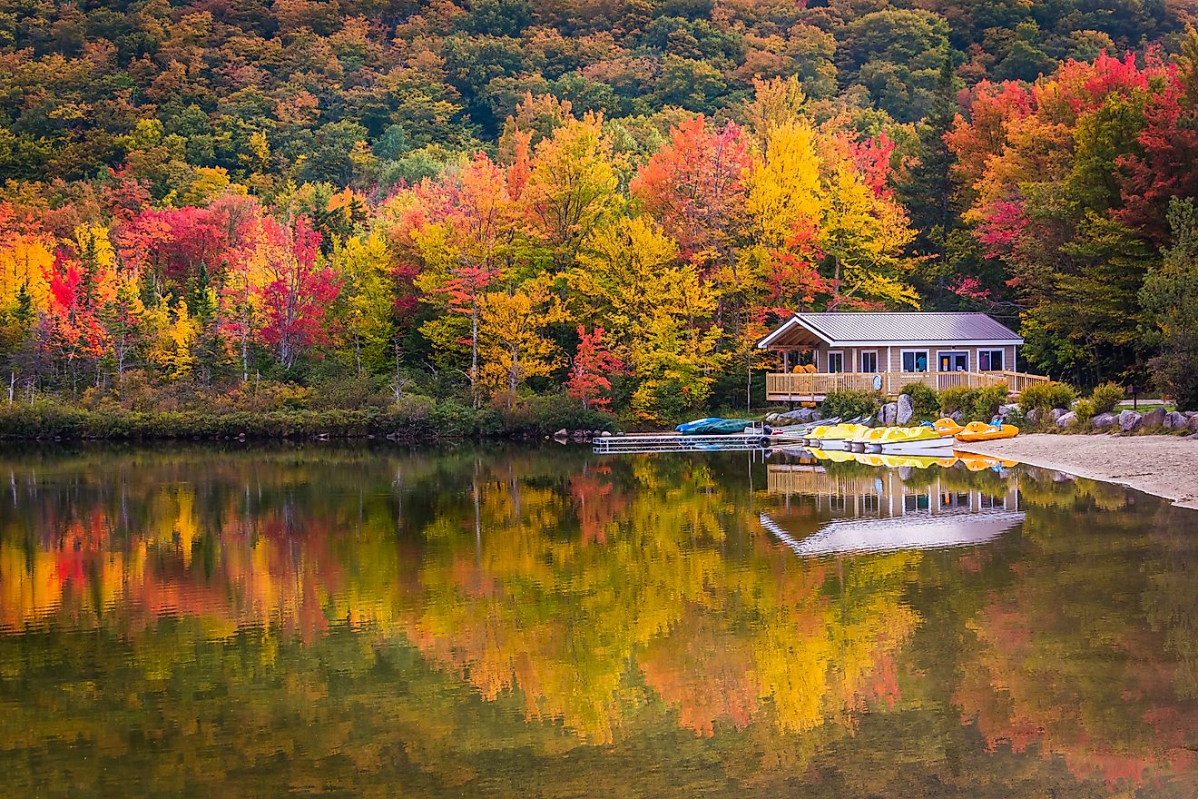 Boathouse and fall colors reflecting in Echo Lake, in Franconia Notch State Park, New Hampshire.