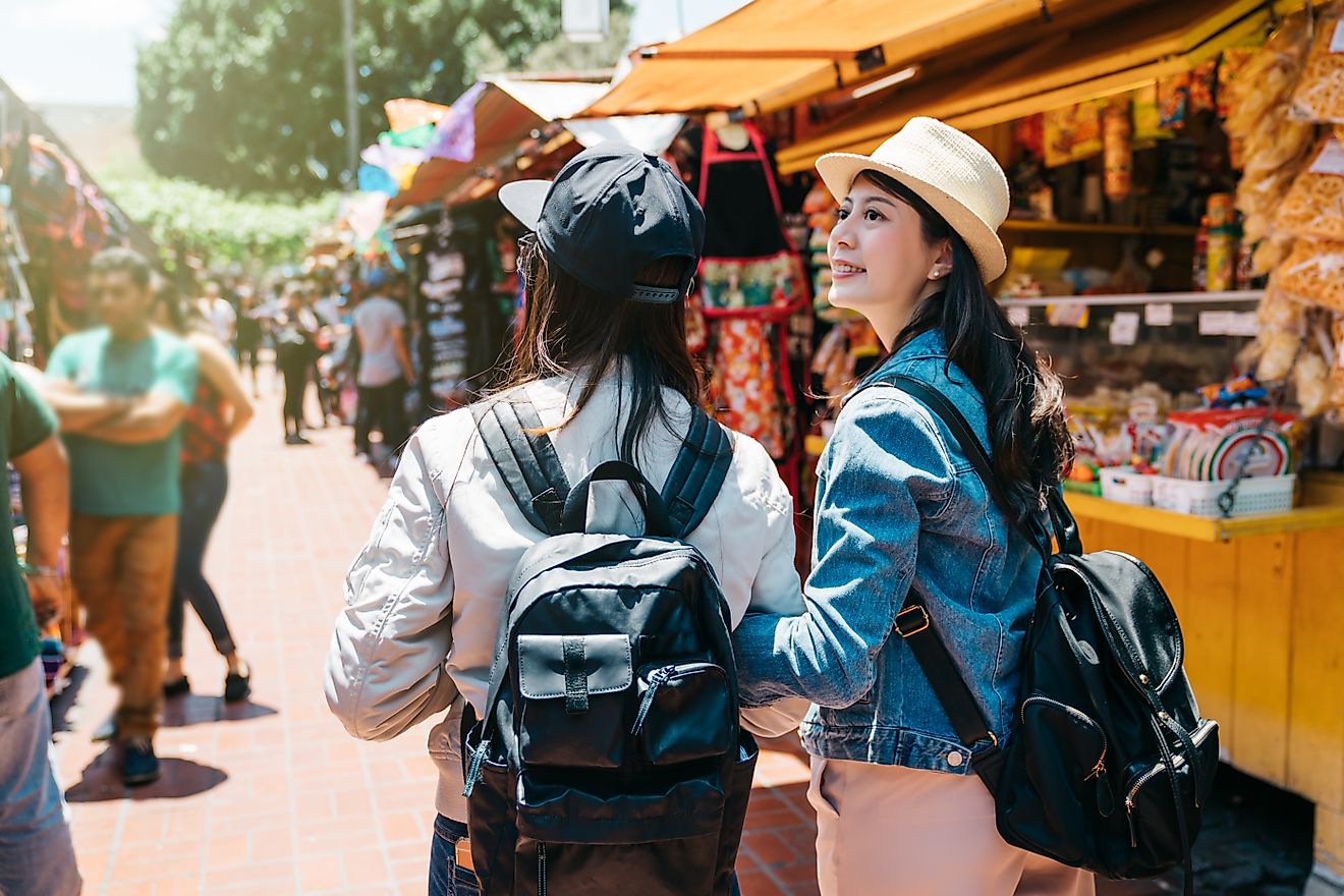 Back view of two female tourists visiting the traditional market in LA.