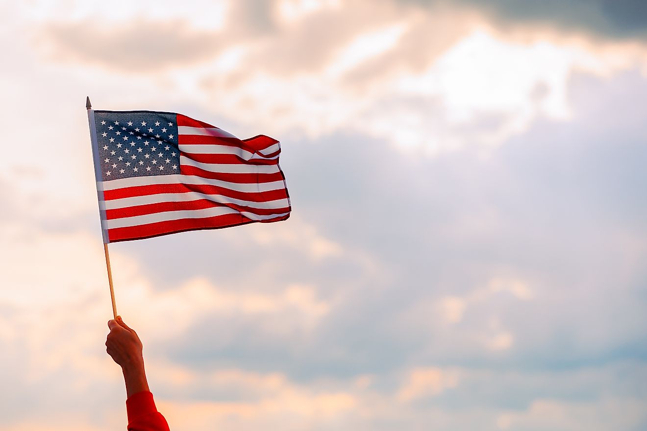 Hand Waving the Flag of the United States of America. Image credits: Nicoleta lonescu via Shutterstock