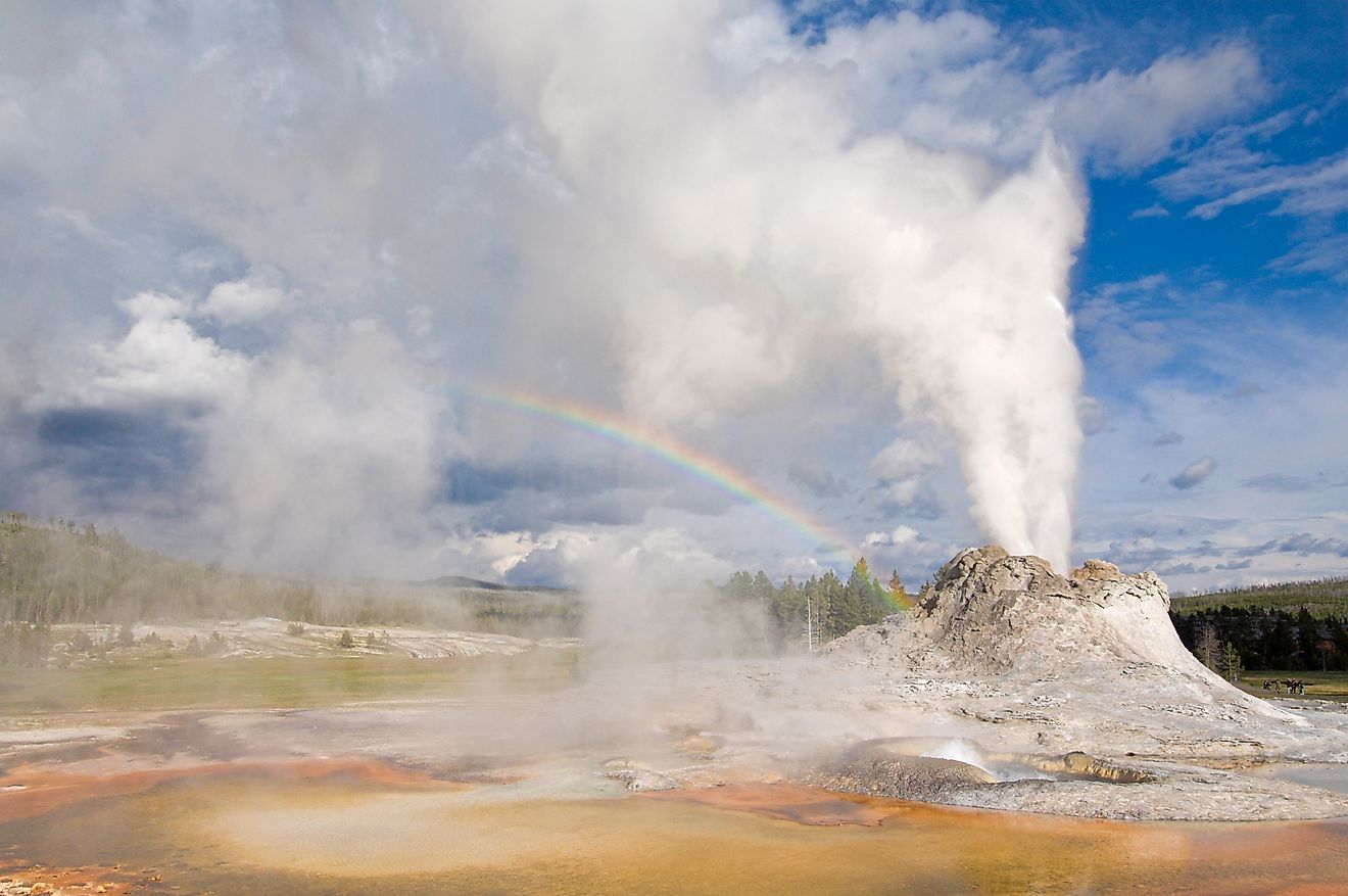 Eruption of castle geyser with rainbow in the spray, upper geyser basin, yellowstone national park