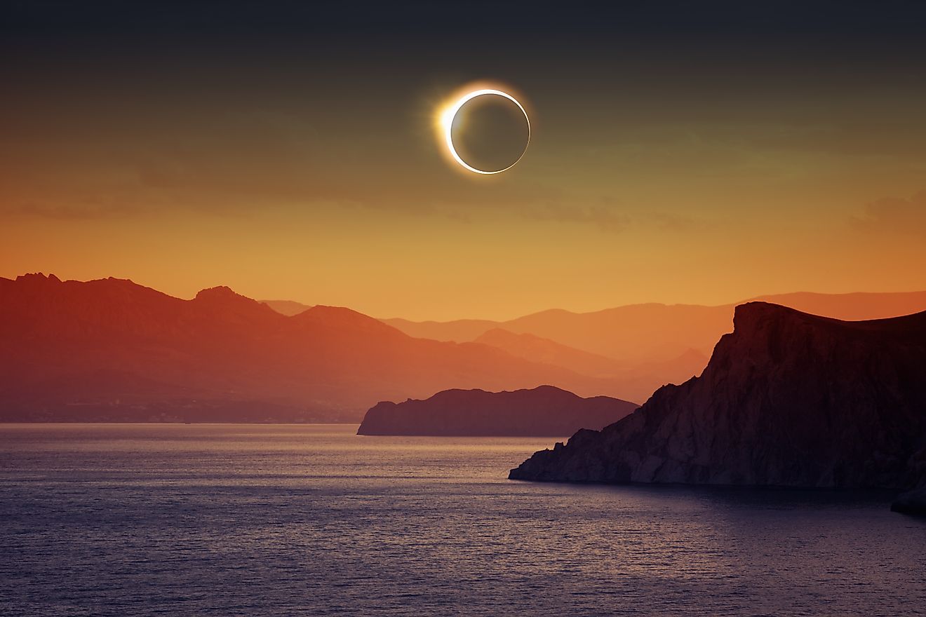 Solar eclipse over mountains and sea. Image credits via Shutterstock. 