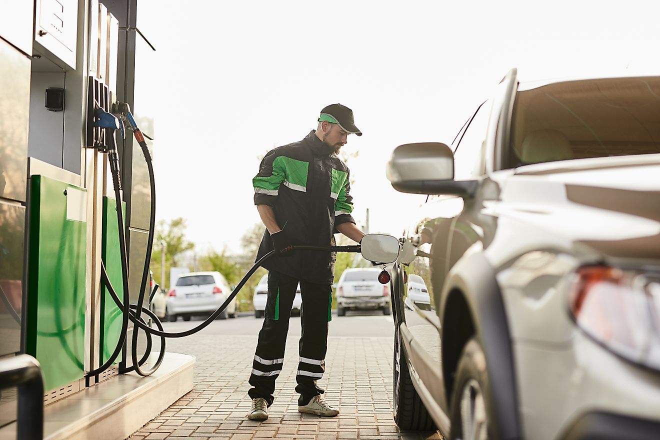 male worker in uniform pumping gas