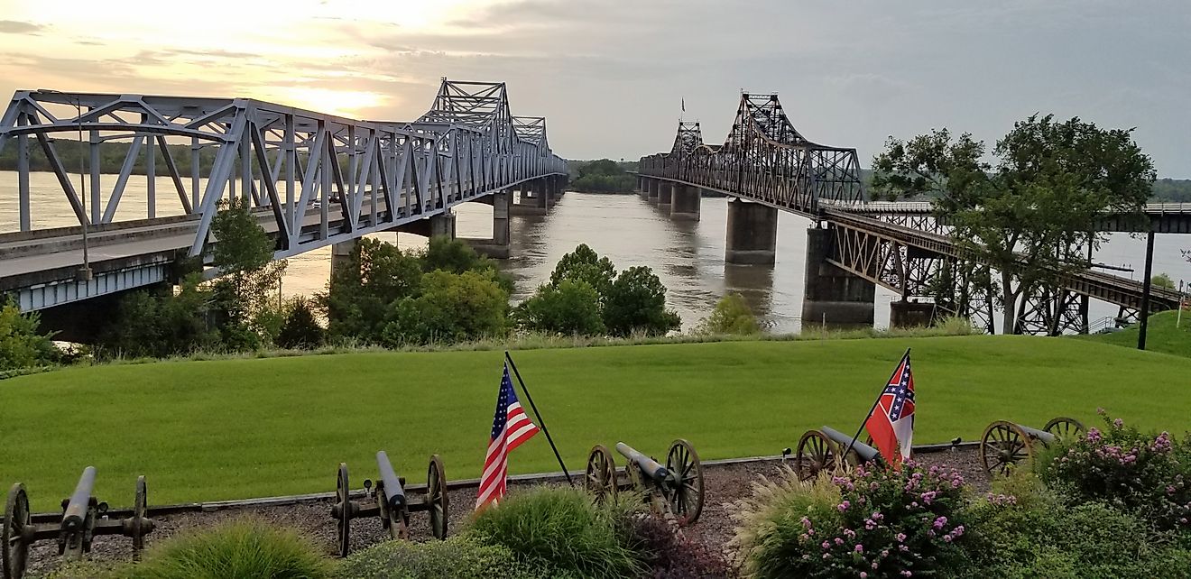 Two bridges crossing the Mississippi River contrasting old and new, railroad and highway, and train and road in Vicksburg, Mississippi