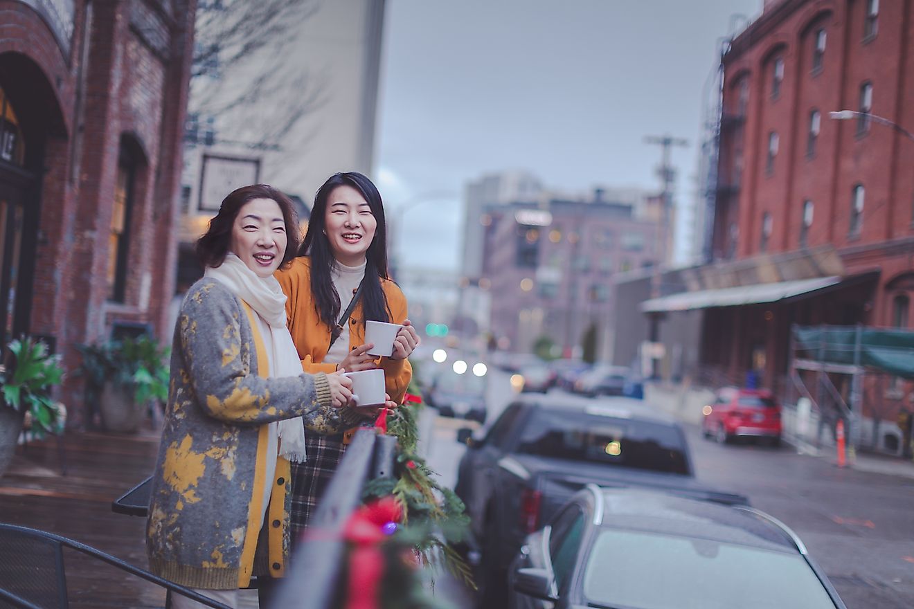 Happy asian elderly mother and adult daughter enjoying coffee at Portland pearl district outdoor cafe