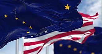 The flags of the Alaska state and United States waving in the wind.