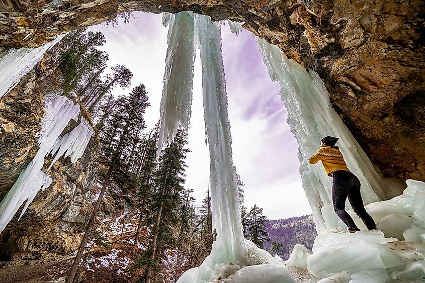 A girl standing under a frozen waterfall in Spearfish, South Dakota