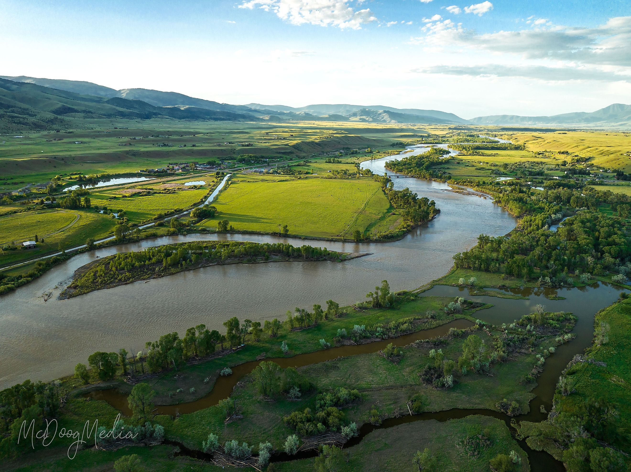 A breathtaking aerial view of Paradise Valley and Yellowstone River under a bright cloudy sky