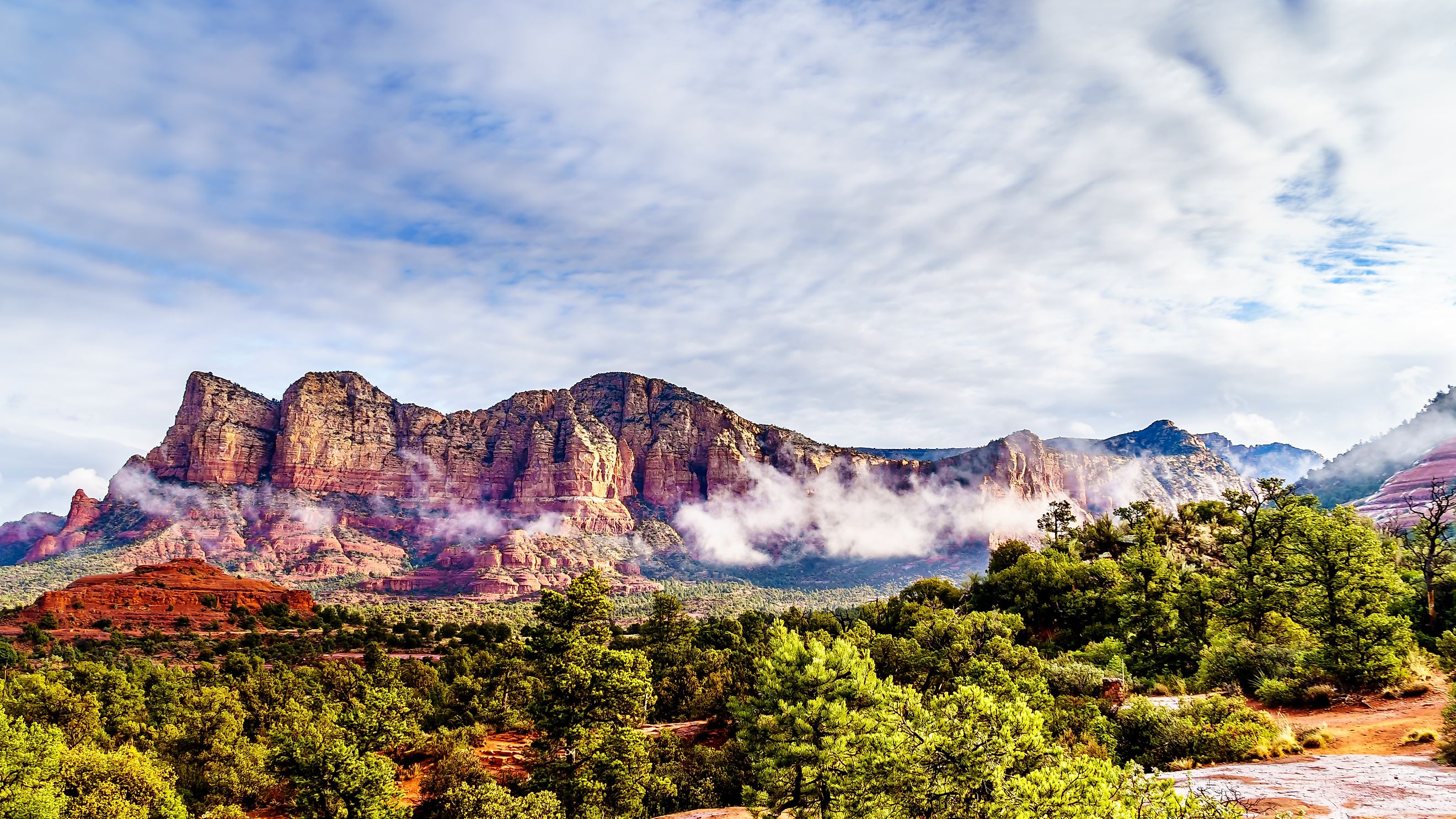 Clouds hanging around Lee Mountain, Munds Mountain and other red rock mountains surrounding the town of Sedona in northern Arizona in Coconino National Forest