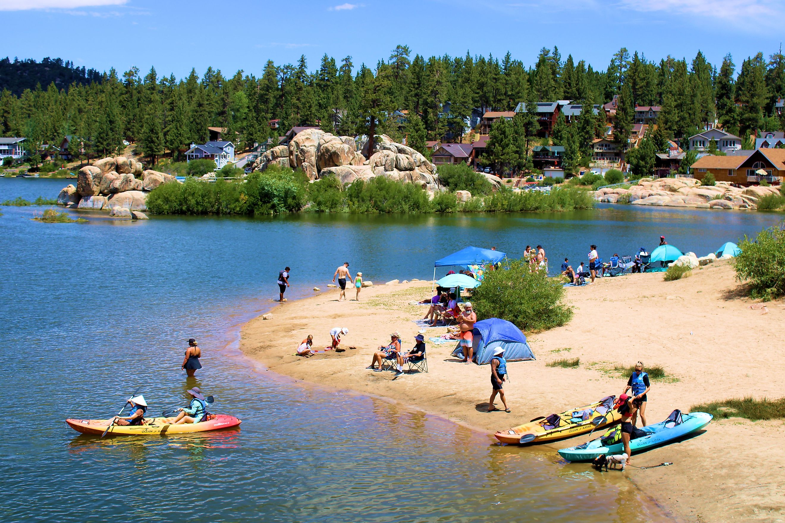 People kayaking besides a sandy beach cove taken in Big Bear Lake, CA. Editorial credit: photojohn830 / Shutterstock.com