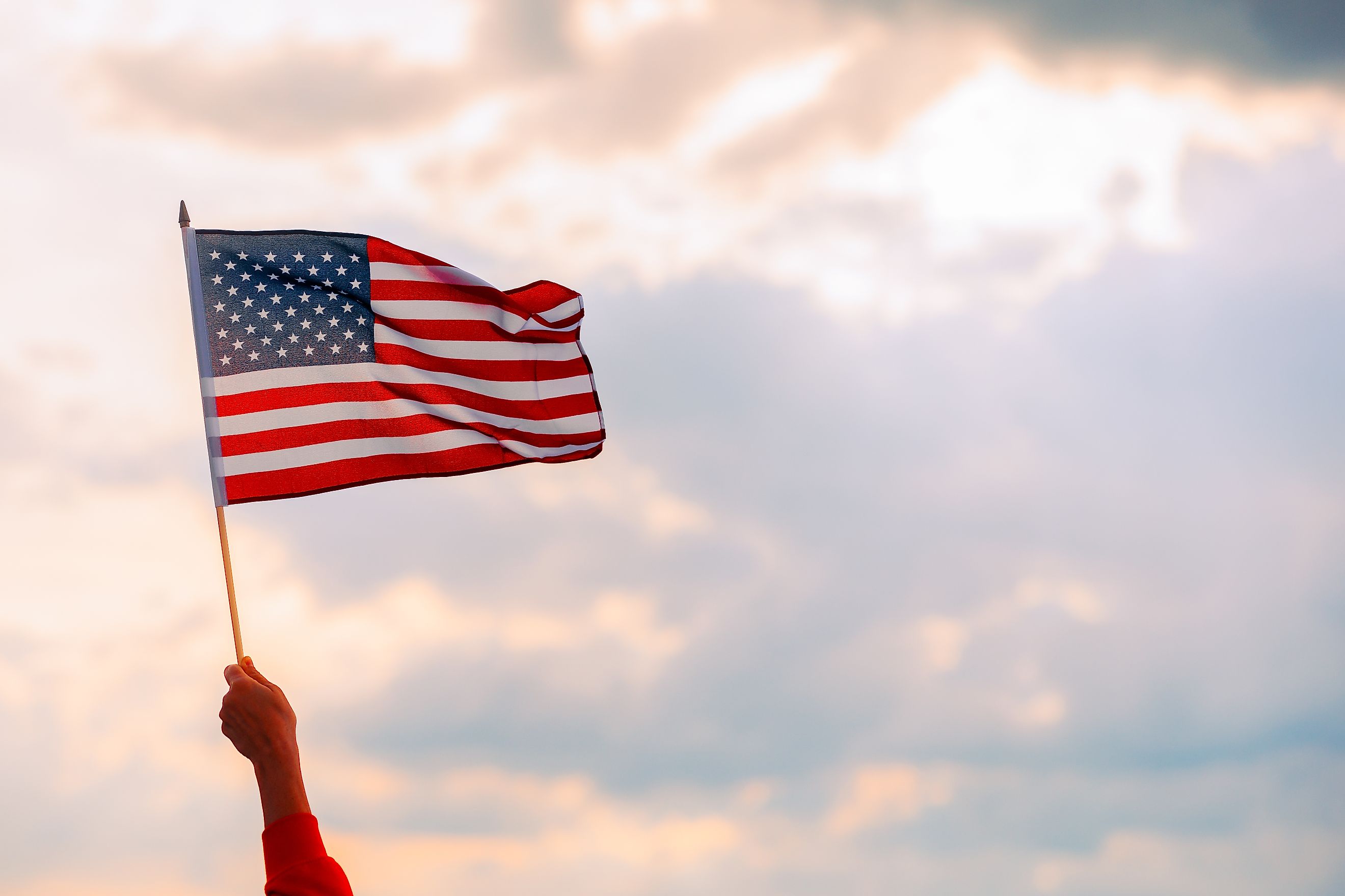 Hand Waving the Flag of the United States of America. Image credits: Nicoleta lonescu via Shutterstock