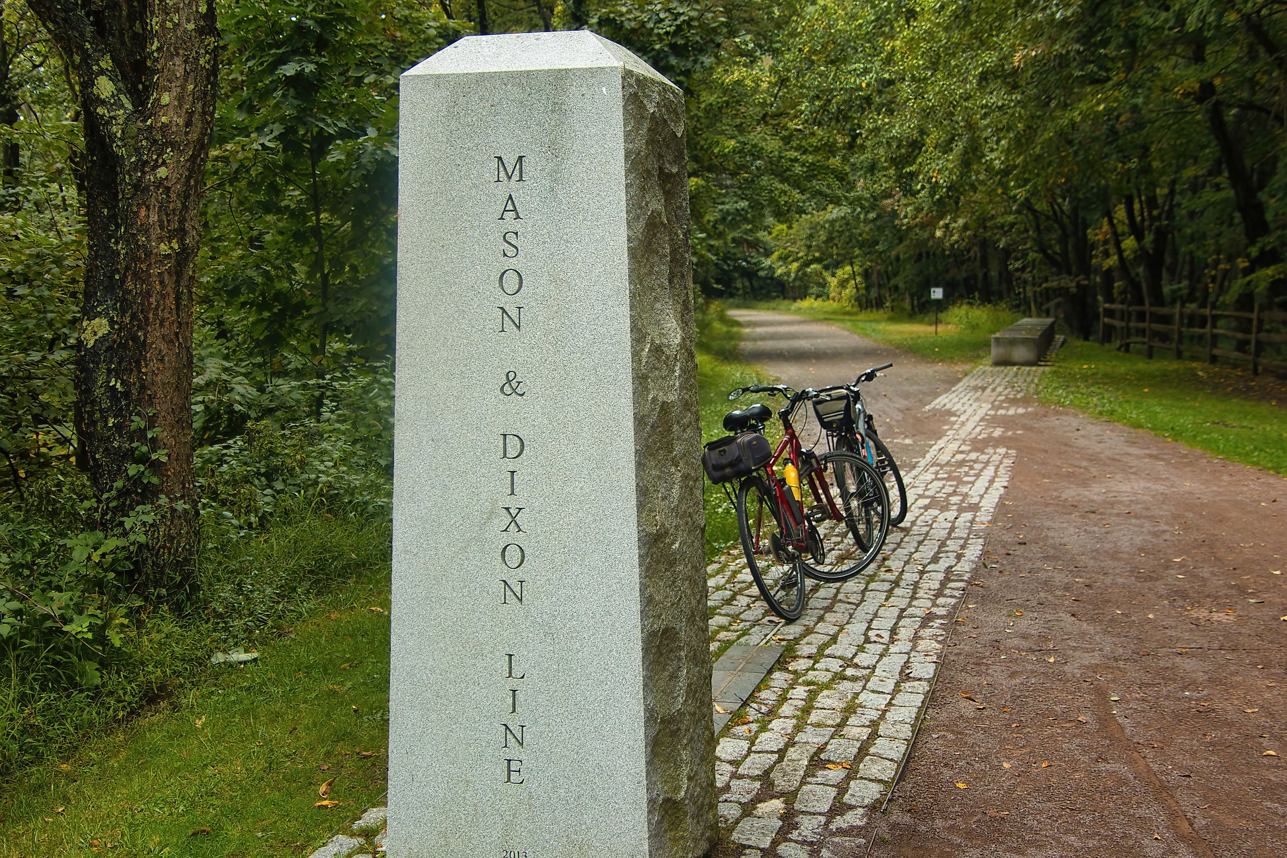  Two bikes are parked by a concrete marker indicating the location where the Great Allegheny Passage crosses the Mason Dixon Line near Frostburg, PA.