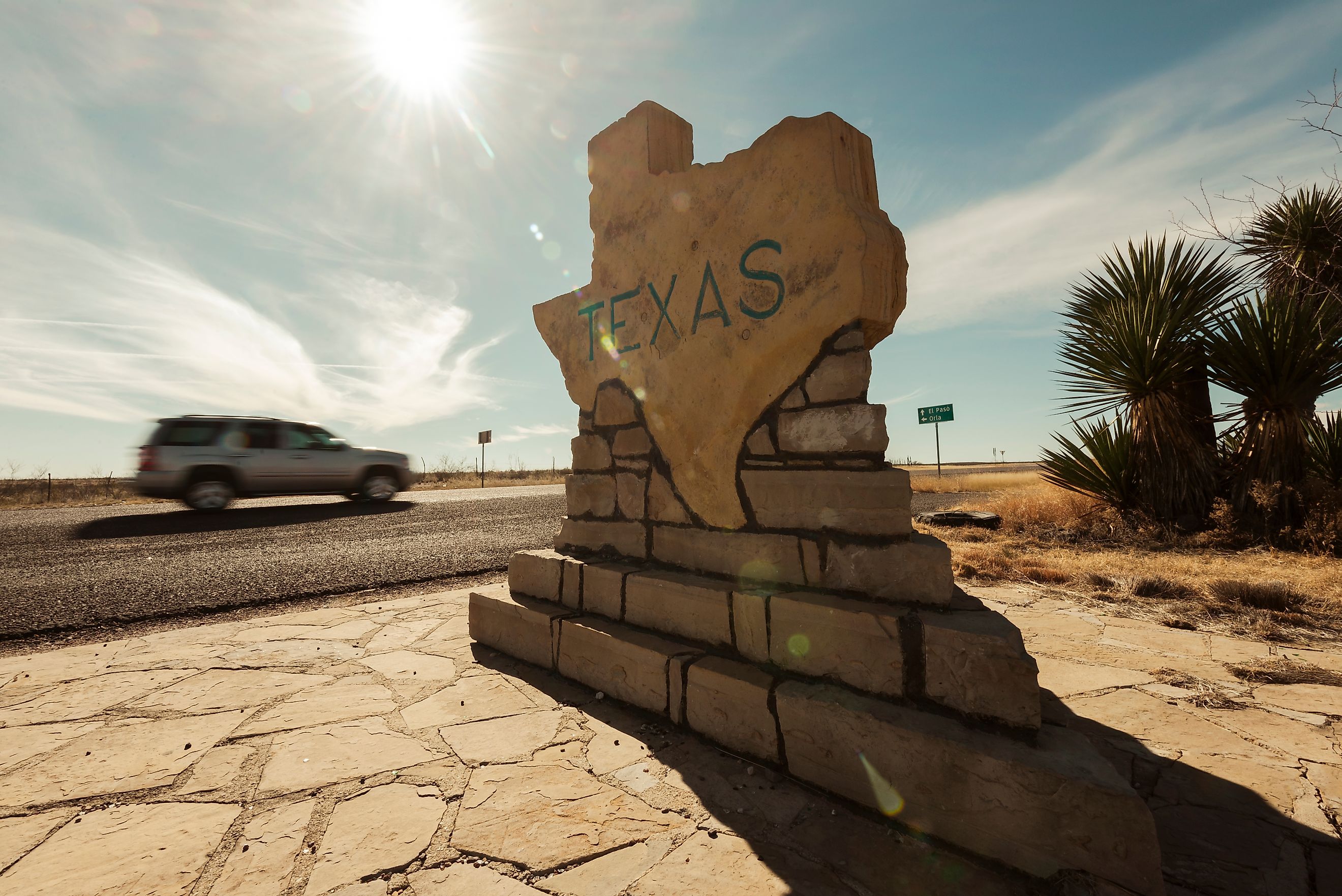 A car speeds along past the Texas border sign from New Mexico near Carlsbad in the USA