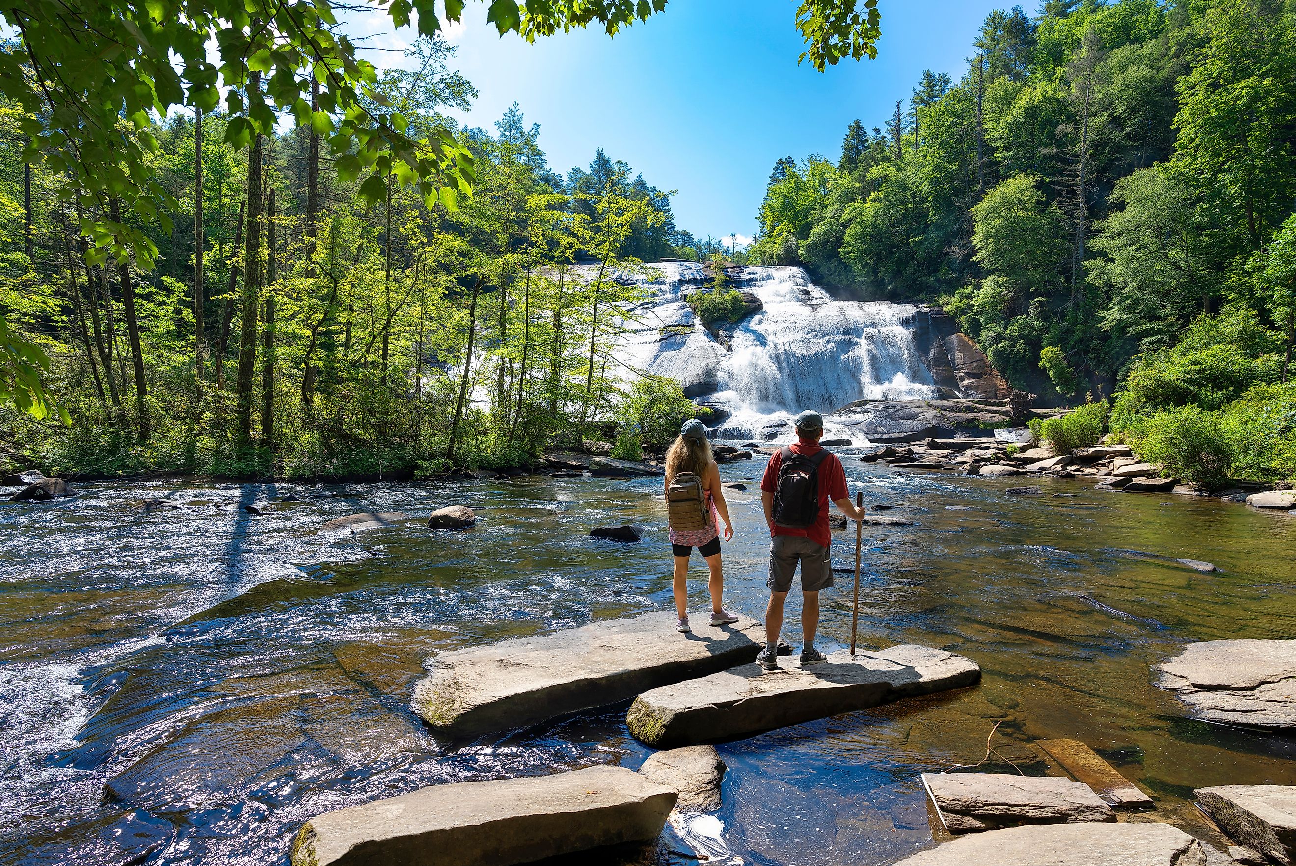 Couple enjoying beautiful waterfall view at Dupont State Forest, near Asheville, North Carolina.