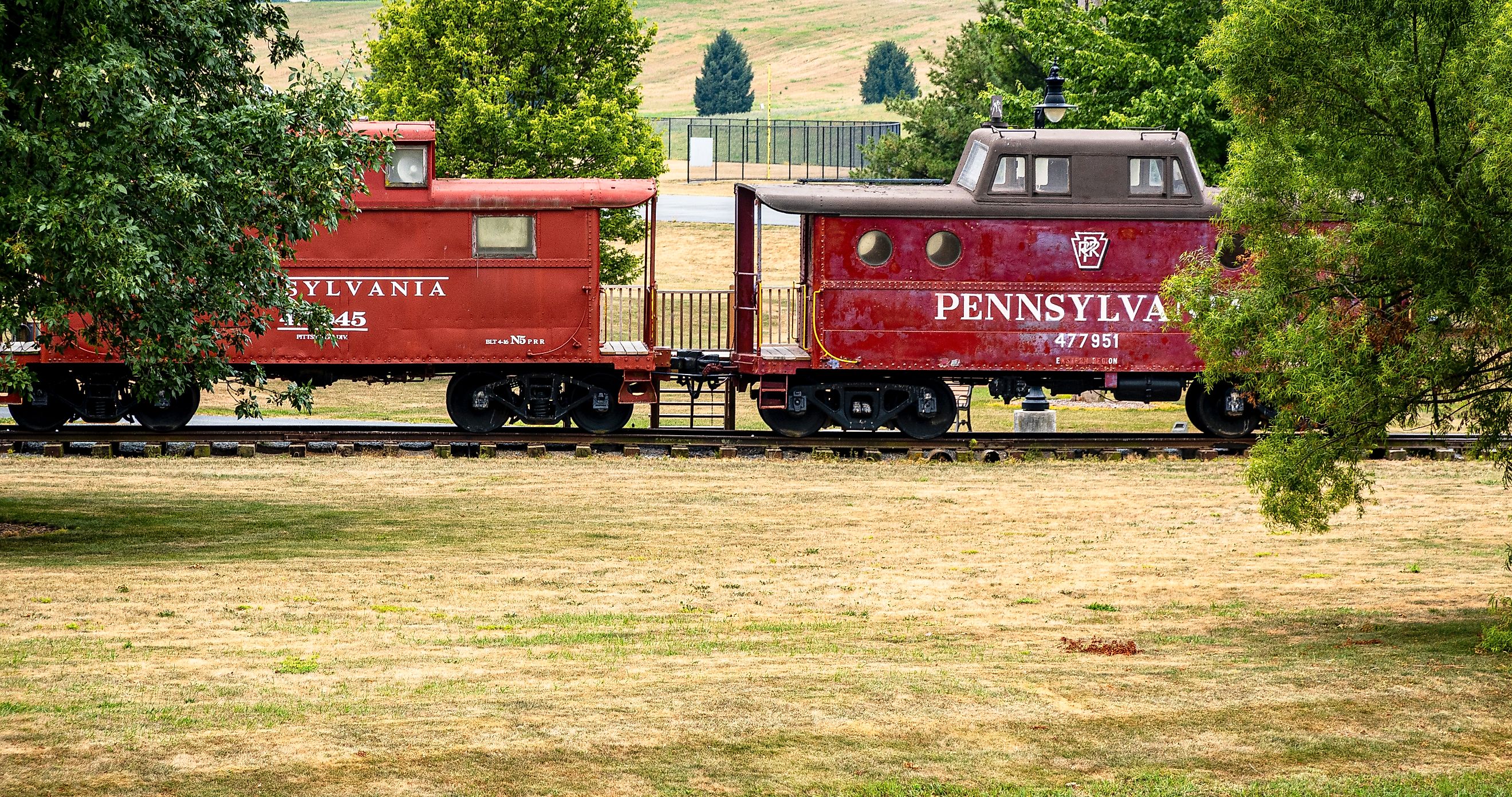 Chambersburg Pennsylvania USA 7-22-2024 Pennsylvania railroad red 1942 cabin car and 1916 unmodified caboose built at Altoona car shops. Editorial credit: Robert Hale / Shutterstock.com