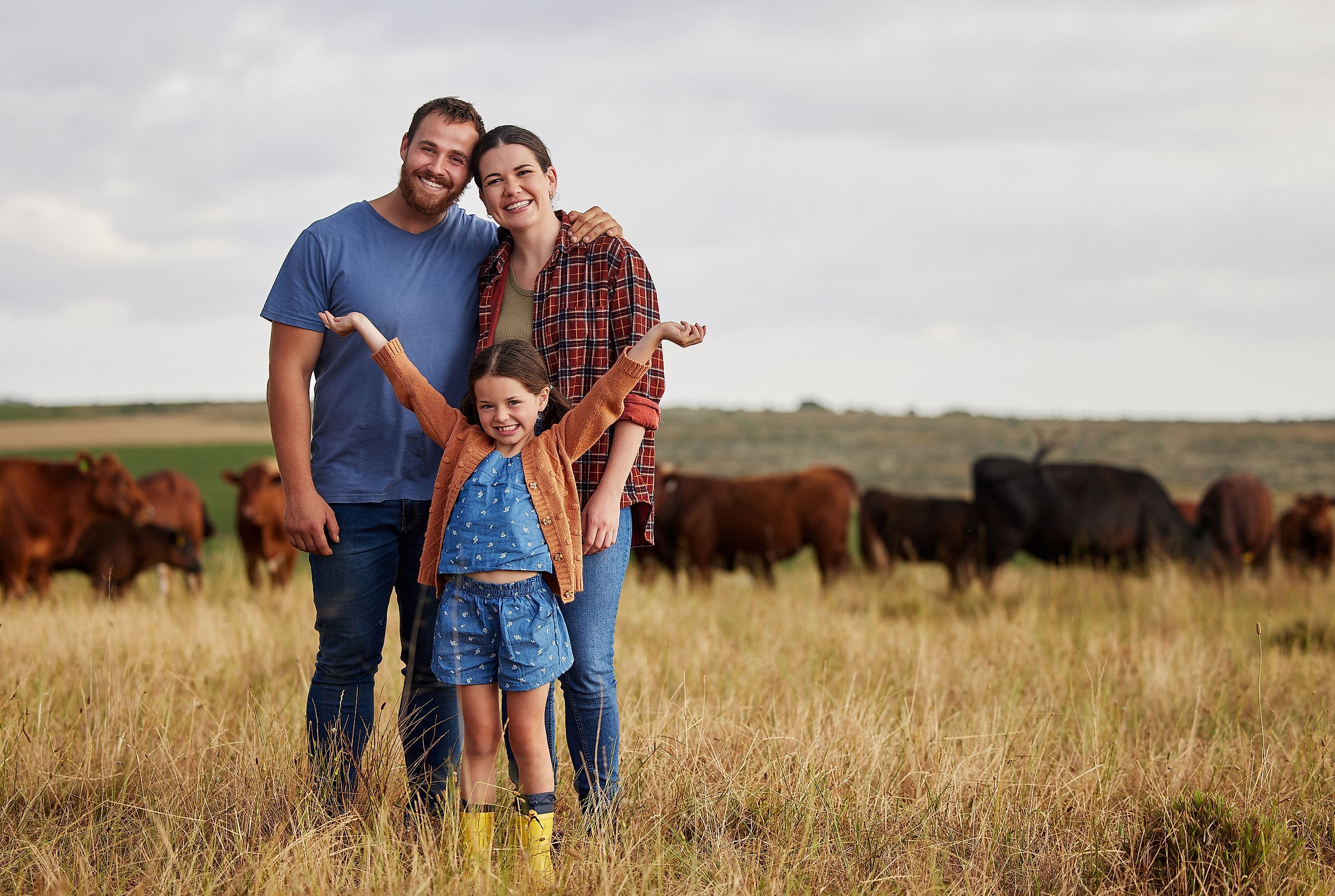 Happy family standing on a farm
